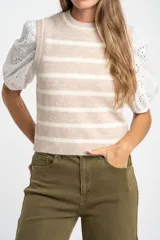 Chaleco de punto sin mangas con diseño de rayas horizontales en tonos beige y blanco, cuello redondo y terminaciones acanaladas.