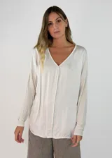 Blusa de manga larga con escote en V, confeccionada en tejido satinado de acabado brillante y corte holgado.