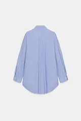 Camisa de corte oversize con cuello solapa, manga larga con puños y bajo asimétrico. Cierre frontal con botones.