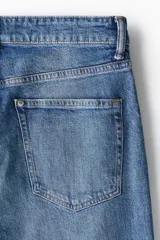 Pantalón jean de corte ajustado y tiro medio, en tono azul clásico con efecto deslavado.