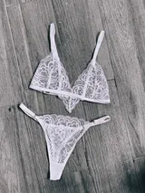 Conjunto de lencería compuesto por un bralette de encaje con diseño floral y una bombacha tipo tanga a juego, ambos en color blanco.