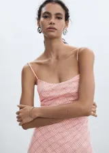 Vestido midi de corte entallado con estampado de cuadros vichy en tonos rosados. Presenta escote cuadrado, tirantes finos y cierre de cremallera invisible en el lateral.