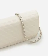 Bolso estructurado de Satinato color blanco, con textura capitoneada, solapa frontal y correa de cadena dorada.
