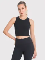 Top crop sin mangas de color negro, confeccionado en tejido acanalado con cuello redondo. Presenta un diseño ajustado al cuerpo con una pequeña abertura en la espalda y una cinta decorativa.