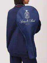 Bolso de tenis azul marino con cierre de cremallera bidireccional y correa de nailon ajustable. Estampado frontal con el logo de Sporty & Rich en color blanco.