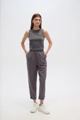 Pantalon de corte relajado, color gris, con cintura elástica y cordón ajustable. Presenta bolsillos frontales tipo parche y puños elásticos en los tobillos.