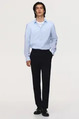 Camisa de vestir slim fit con diseño a rayas celestes y blancas, cuello inglés, cierre frontal de botones y mangas largas con puños abotonados.