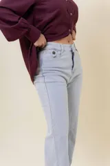 Pantalón de jean estilo wide leg, color celeste claro, con tiro medio, cinco bolsillos y cierre frontal con botón y cremallera.