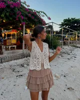 Minifalda beige de volantes en capas, con cintura elástica y short incorporado debajo.