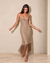 Vestido midi tejido de hilo lurex en color tostado, con tirantes finos, escote en V con abertura frontal y terminación con flecos largos en el ruedo.