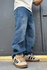 Pantalón de denim azul con diseño balloon y costuras curvas decorativas en las piernas.