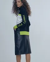 Sweater de tejido fino con cuello alto, diseño de bloques de color en azul marino, blanco y fucsia. Presenta el nombre de la marca estampado en la manga en color fucsia.