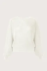 Sweater de punto color blanco con textura en relieve, cuello redondo y mangas largas abullonadas con puños ajustados.