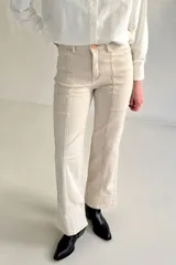 Jeans de denim color beige, de tiro alto y corte recto, con costuras verticales decorativas en el frente.