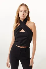 Top negro estilo halter confeccionado en lino, con ajuste cruzado en el cuello y calce al cuerpo.