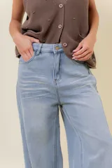 Jean de tiro alto con calce wide leg, confeccionado en denim de lavado celeste claro. Presenta una estructura firme y un interior forrado para mayor abrigo, con bolsillos funcionales.