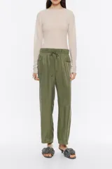 Pantalón de lino negro lavado, estilo jogger, largo tobillero, con cintura fruncida con cordones de tejido y bolsillos laterales con vivo.