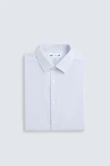 Camisa de algodón de manga larga, color celeste claro, con cuello italiano y cierre frontal de botonadura.