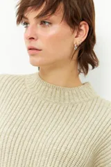 Polera marrón de tejido de punto con cuello alto y corte oversized.