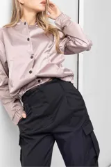 Pantalón gris de tiro alto con pinzas, bolsillos cargo laterales y ruedo ajustable con botones.