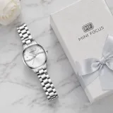 Reloj analógico de mujer con caja y malla de acero inoxidable plateado. Presenta una esfera con diseño texturizado en espiral, detalles de cristales y cierre desplegable con botón de seguridad.