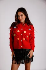 Saco rojo de tejido de punto con flores bordadas en relieve y botones blancos.