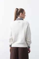 Sweater de punto tramado color azul marino, con cuello redondo, mangas abullonadas y puños elastizados.