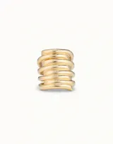 Anillo dorado de metal con forma de espiral irregular, de la marca UNOde50. Diseño de anillos apilados con acabado artesanal.