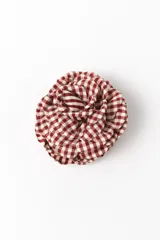 Broche en forma de flor con diseño de tela a cuadros vichy en color rojo y blanco.