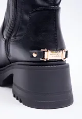 Bota corta negra de cuero sintético, con punta redondeada, plataforma de 6cm, cierre lateral y detalle metálico dorado en la parte trasera del taco.