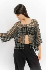 Blusa blanca de encaje con diseño de flores pequeñas entrelazadas, de corte holgado y mangas tres cuartos.