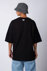 Remera de corte oversize, color blanco, con cuello redondo y mangas cortas amplias.