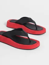 Sandalias tipo ojotas con plataforma roja y tiras negras.