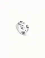 Anillo abierto plateado con dos pequeñas cabezas de clavo.