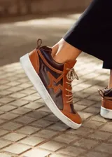 Zapatillas de cuero color marrón con detalles en marrón oscuro y estrella en el lateral.