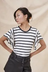 Remera blanca con rayas horizontales negras, cuello redondo y mangas cortas con volados.