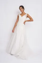 Vestido de novia blanco de seda y organza con apliques de cruni, bordados en perlas y canutillos. Sin mangas, con breteles transparentes y espalda terminada en V con cinta para cerrar tipo corset.