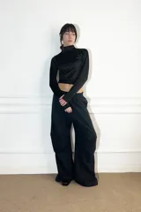 Polera negra de lycra, corte crop top, cuello alto y mangas largas con orificios para los pulgares.