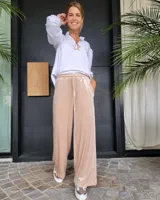 Pantalón de corte amplio y tiro medio, confeccionado en terciopelo color beige. Presenta cintura elástica con cordón ajustable y bolsillos laterales.