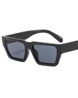 Lentes de sol negros con marco rectangular grueso y lentes grises.