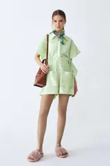 Short verde de lino con bolsillos delanteros, cintura elastizada y cordón ajustable en blanco y negro.