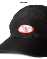 Gorra negra de cinco paneles, confeccionada en tela dry-fit, con logo bordado en rojo.