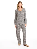 Conjunto de pijama compuesto por una remera de manga larga con escote en V, abertura frontal con botones y bolsillo aplicado, y un pantalón con cintura elástica y lazo de ajuste. Presenta un estampado animal print en tonos neutros.