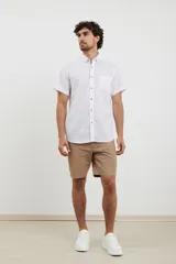 Camisa azul de manga corta, con cuello abotonado y bolsillo en el pecho.