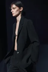 Blazer negro de Zara Woman Collection, con cuello solapa, manga larga con abertura y botones, bolsillos de plastrón en delantero, forro interior a tono y cierre frontal con botones.