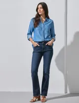 Camisa de manga larga de lyocell color azul claro, con cuello con solapa, escote en V y abertura central con botones. Presenta dos bolsillos aplicados en el frente.