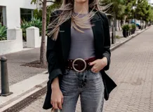 Cinto ancho color marrón con hebilla circular dorada y detalles de tachas pequeñas.