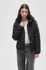 Campera acolchada de color beige con diseño capitoneado en forma de rombos, cierre frontal completo y capucha integrada.