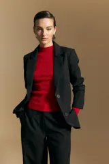 Blazer de corte sastrero con solapas clásicas y estructura definida. Presenta un diseño versátil con silueta ligeramente oversized, ideal para un estilo sofisticado y atemporal.