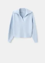 Jersey de punto celeste con cuello polo, escote en V y mangas largas con puños ajustados.